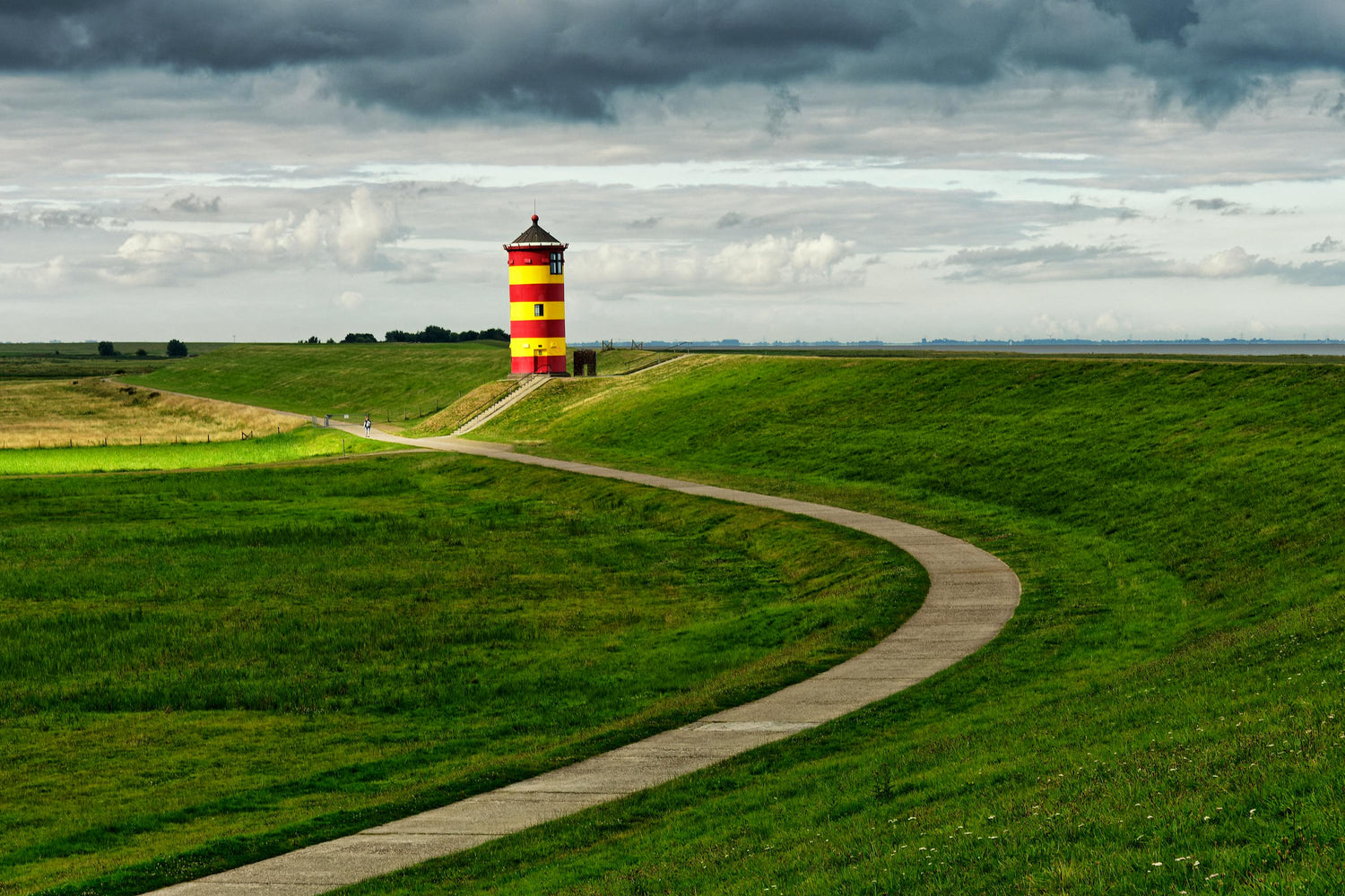 Leuchtturm auf grüner Wiese in Ostfriesland